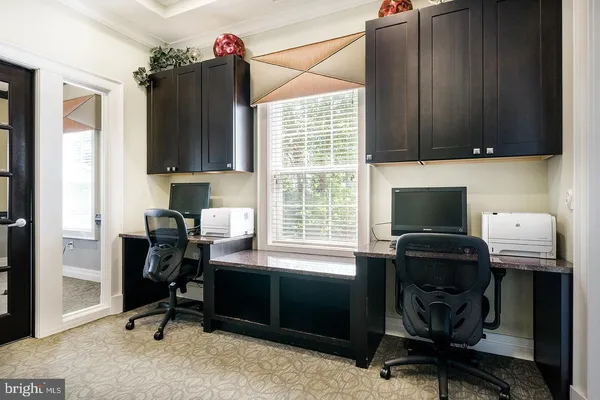 a view of a workspace with furniture and a window