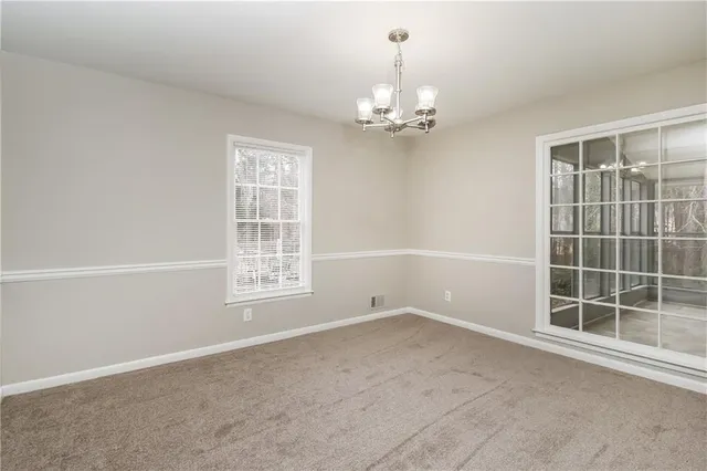 en empty room with windows and ceiling fan