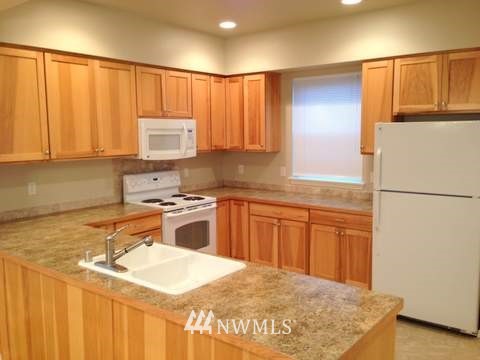 24057 Witte Road Southeast Maple Valley, WA 98038 - Photo 6 of 8 a kitchen with stainless steel appliances granite countertop a sink stove and refrigerator