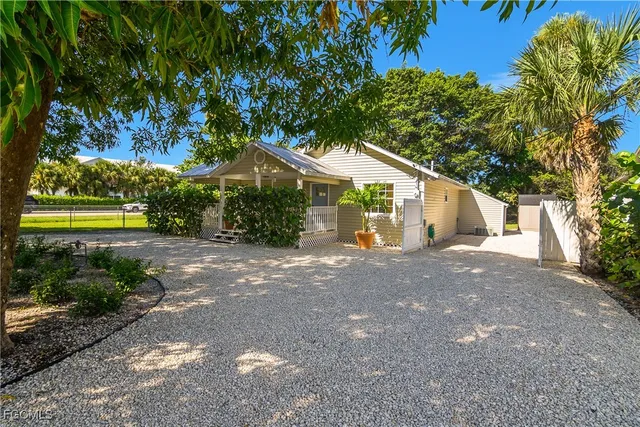 a view of a house with a yard and large tree