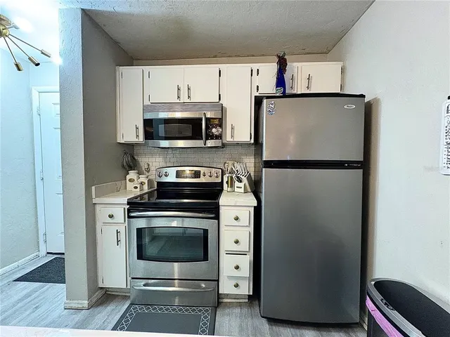 a kitchen with a sink a stove and cabinets