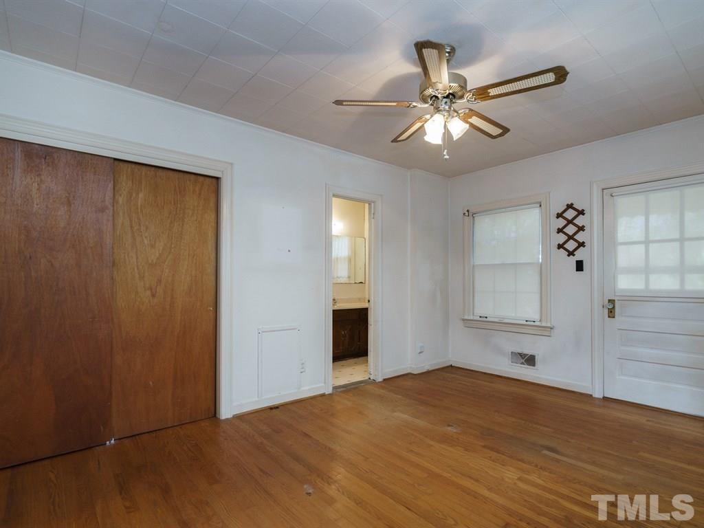 713 Kimbrough Street Raleigh, NC 27608 - Photo 14 of 25 a view of an empty room with wooden floor and a ceiling fan
