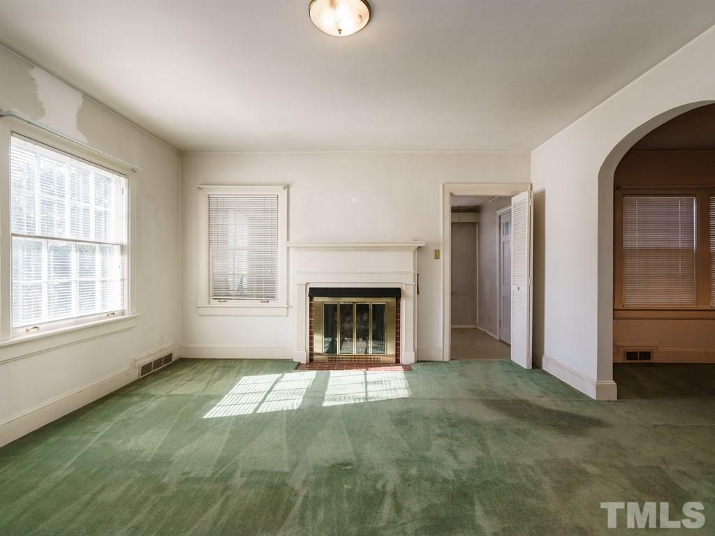 713 Kimbrough Street Raleigh, NC 27608 - Photo 4 of 25 a view of an empty room with a fireplace and a window