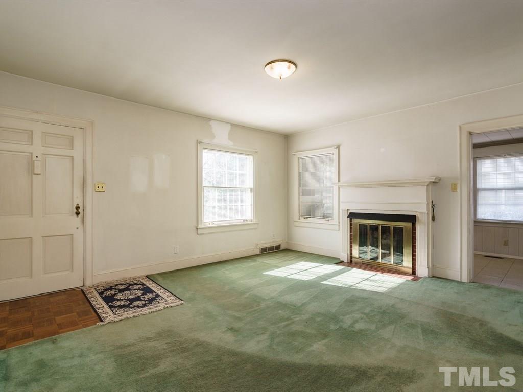 713 Kimbrough Street Raleigh, NC 27608 - Photo 5 of 25 an empty room with windows and fireplace