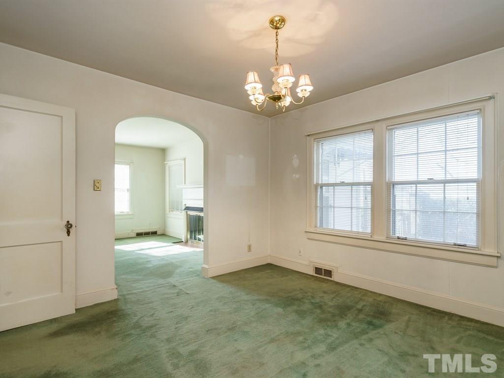 713 Kimbrough Street Raleigh, NC 27608 - Photo 7 of 25 an empty room with chandelier and windows