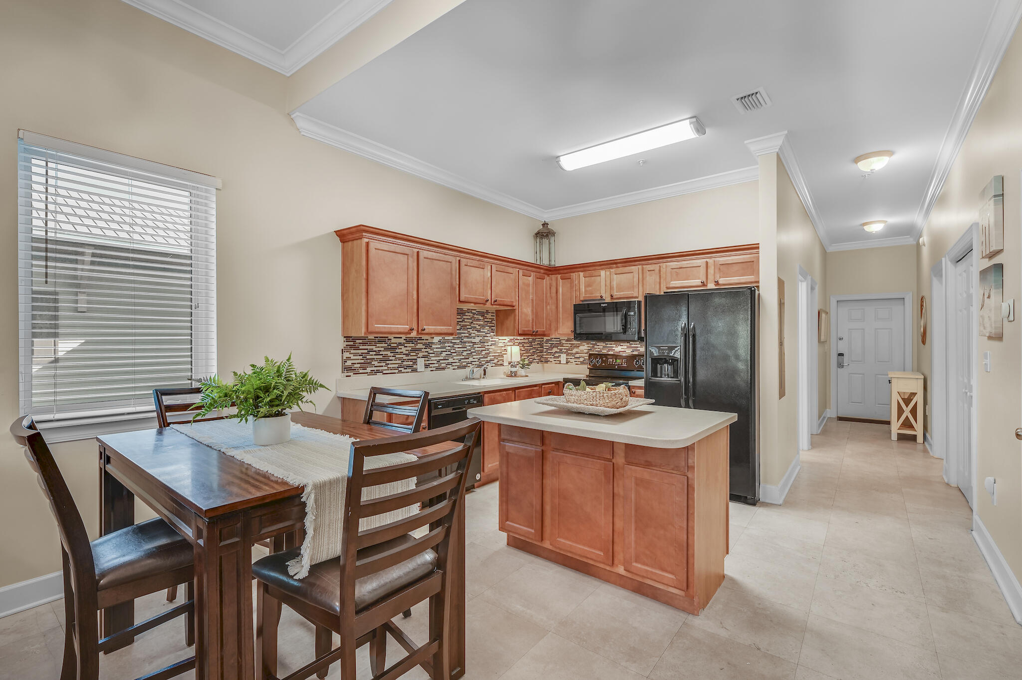 231 Somerset Bridge Road, Unit 1401 Santa Rosa Beach, FL 32459 - Photo 15 of 38 a kitchen with a table chairs refrigerator and cabinets