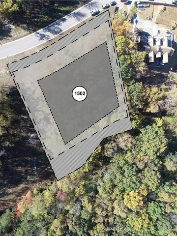 an aerial view of a house with a garden and lake view