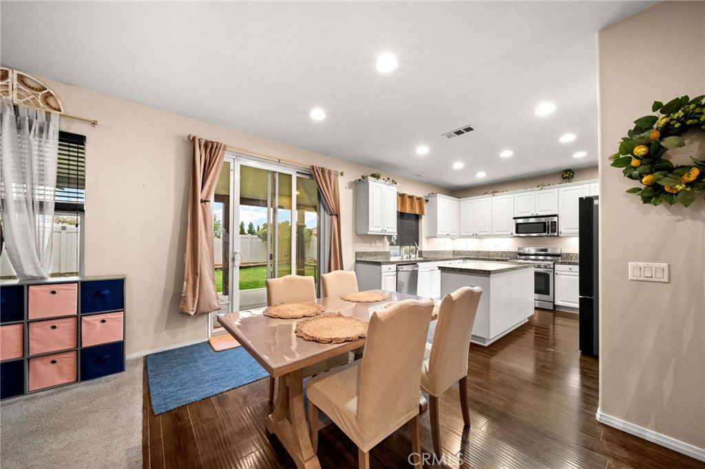 11345 Sanders Street Beaumont, CA 92223 - Photo 11 of 56 a dining room with furniture and wooden floor