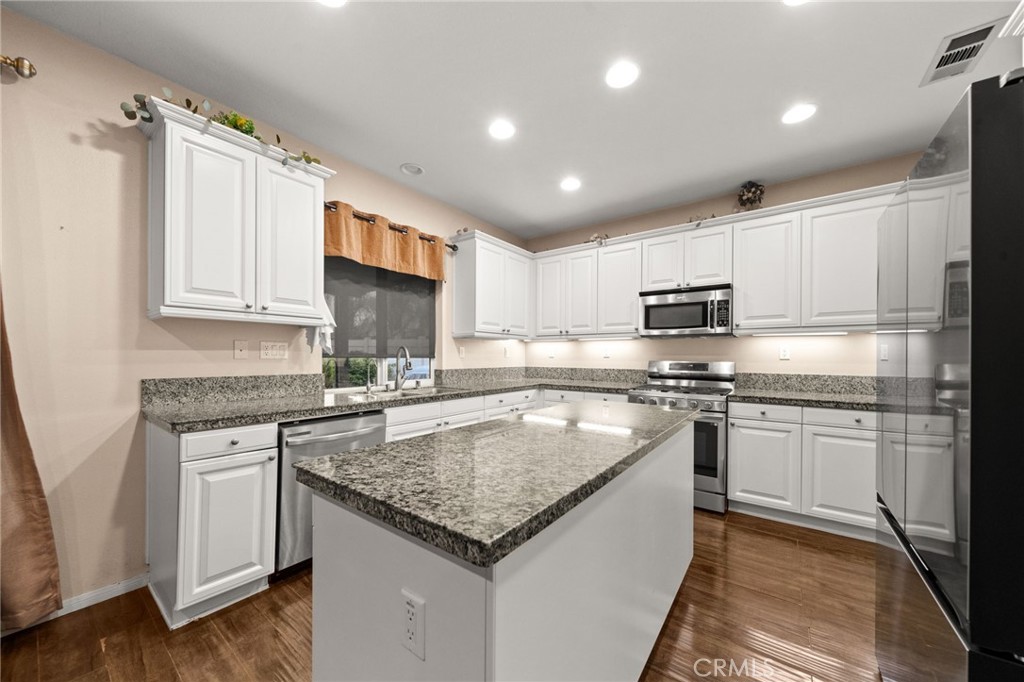 11345 Sanders Street Beaumont, CA 92223 - Photo 12 of 56 a kitchen with stainless steel appliances granite countertop a sink stove microwave and refrigerator
