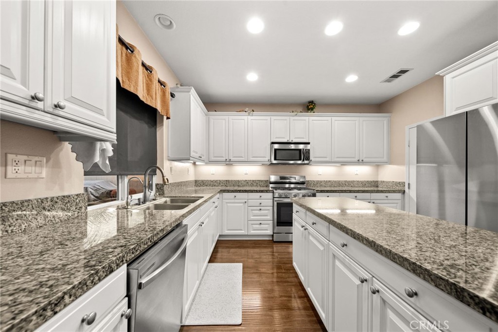 11345 Sanders Street Beaumont, CA 92223 - Photo 13 of 56 a large kitchen with stainless steel appliances granite countertop a sink a stove and a refrigerator
