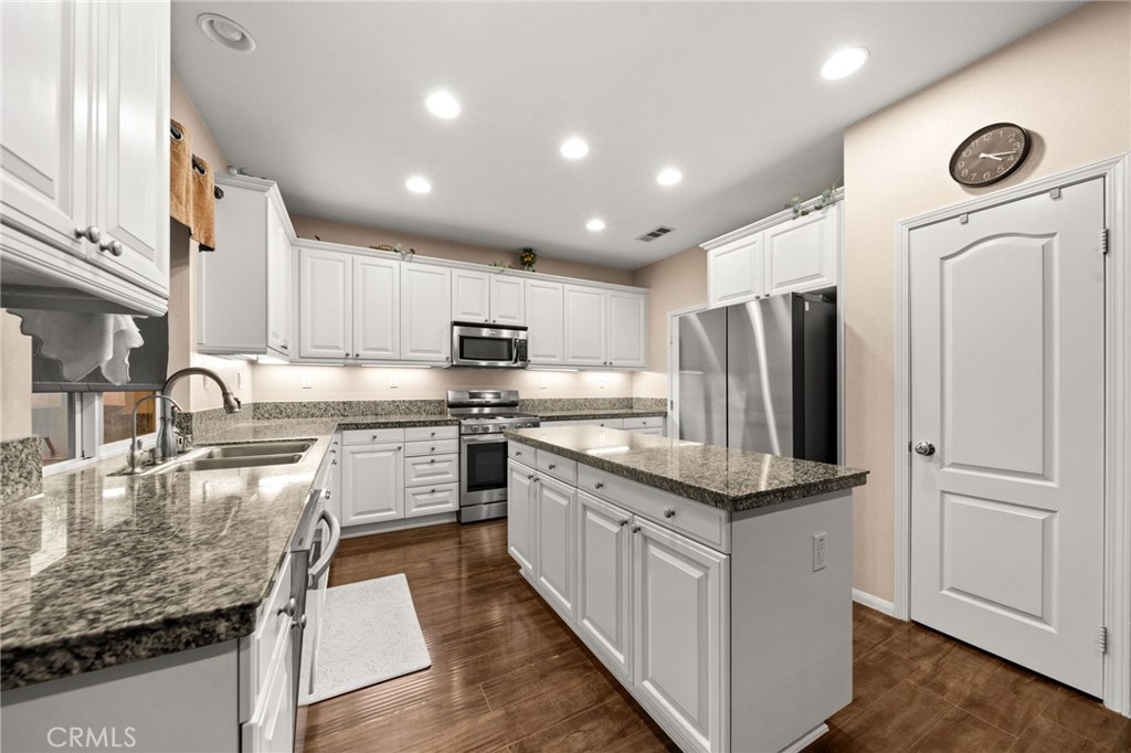 11345 Sanders Street Beaumont, CA 92223 - Photo 14 of 56 a large kitchen with stainless steel appliances granite countertop a sink a stove and a refrigerator