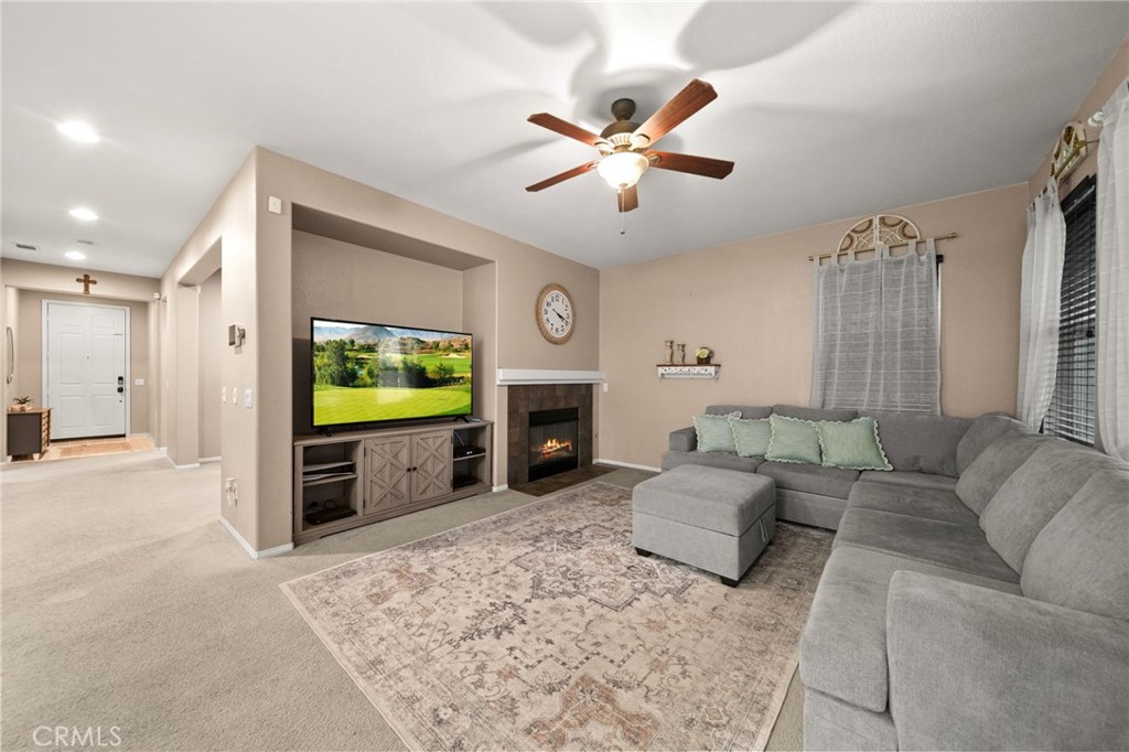11345 Sanders Street Beaumont, CA 92223 - Photo 21 of 56 a living room with furniture a flat screen tv and a fireplace