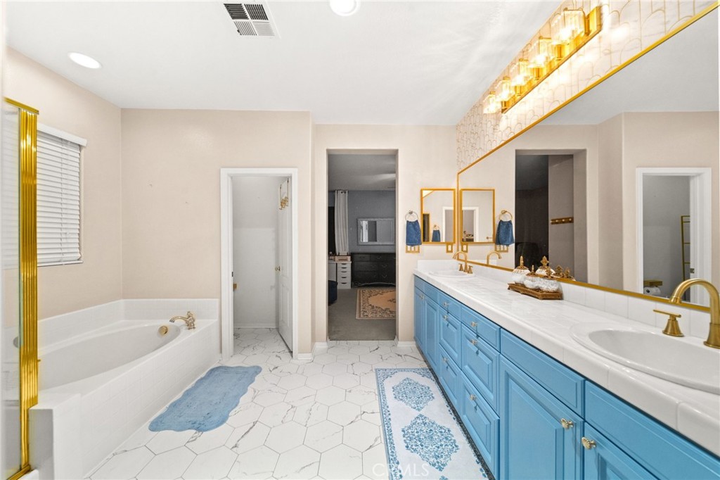 11345 Sanders Street Beaumont, CA 92223 - Photo 46 of 56 a spacious bathroom with a tub sink and mirror