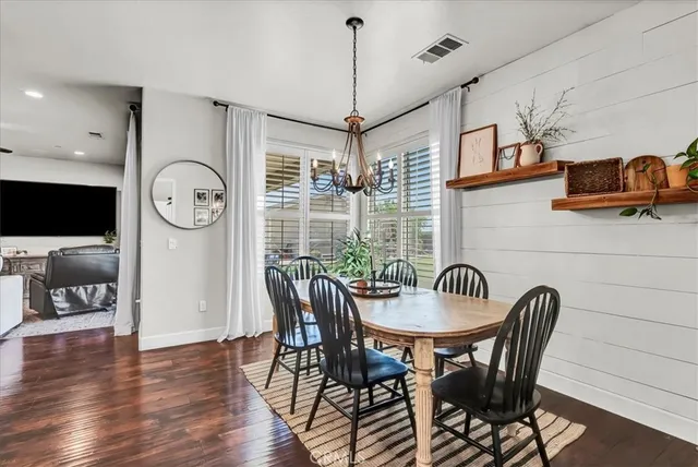 a dining room with furniture potted plants and wooden floor