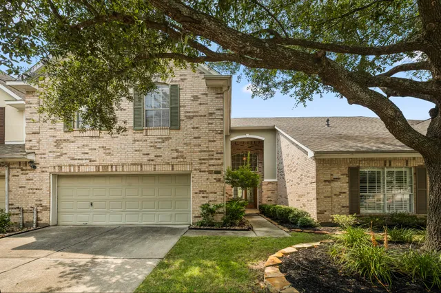 a front view of a house with a garden and yard