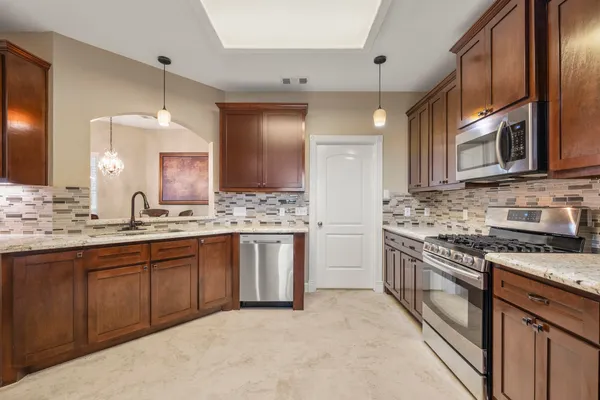 a kitchen with stainless steel appliances granite countertop a sink stove and refrigerator