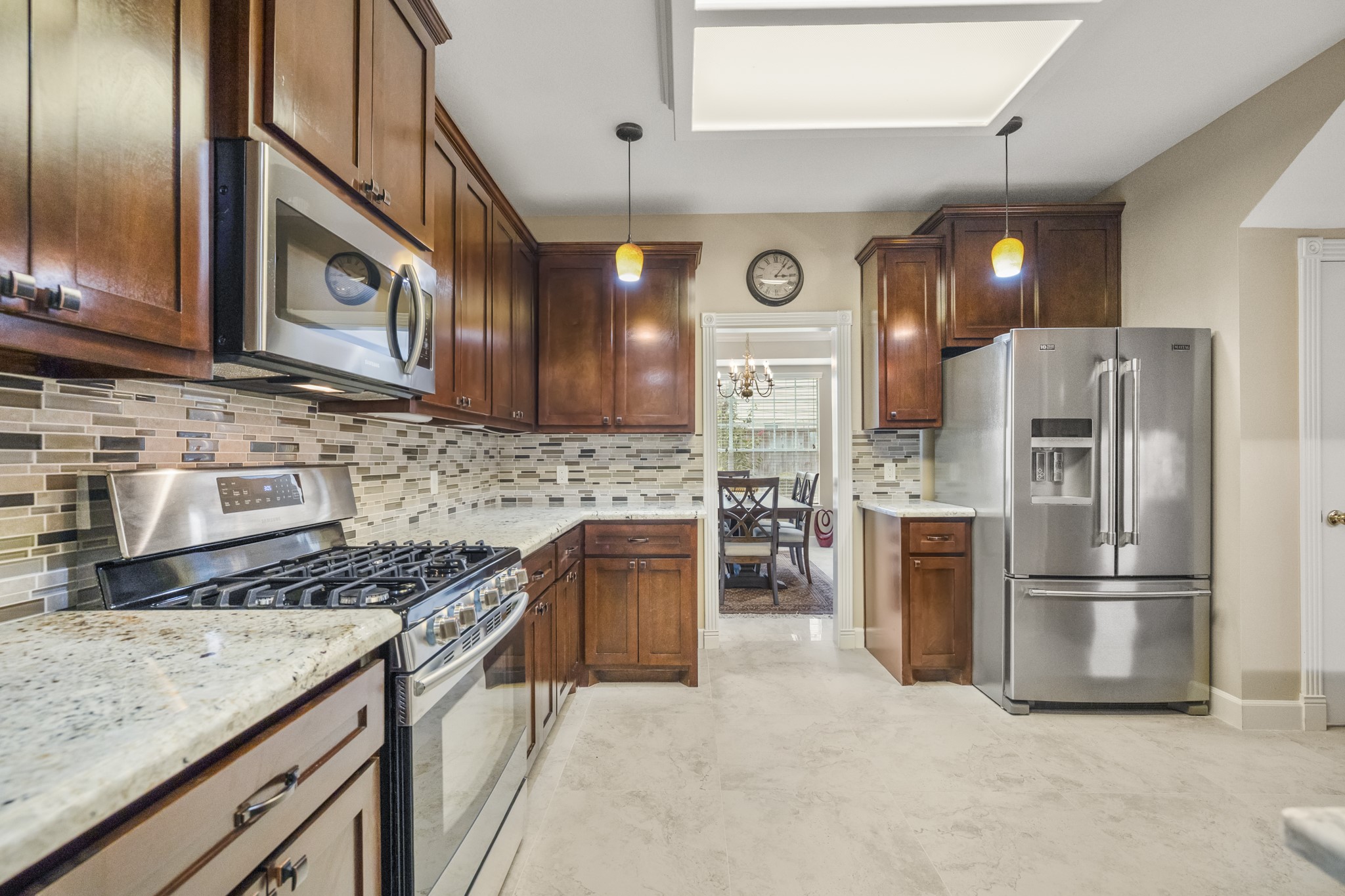 6830 Jasmine Place Spring, TX 77379 - Photo 13 of 38 a kitchen with granite countertop stainless steel appliances and wooden cabinets