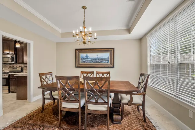 a view of a dining room with furniture and chandelier