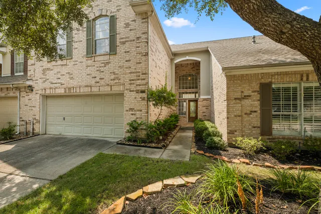 a front view of a house with a garden and plants