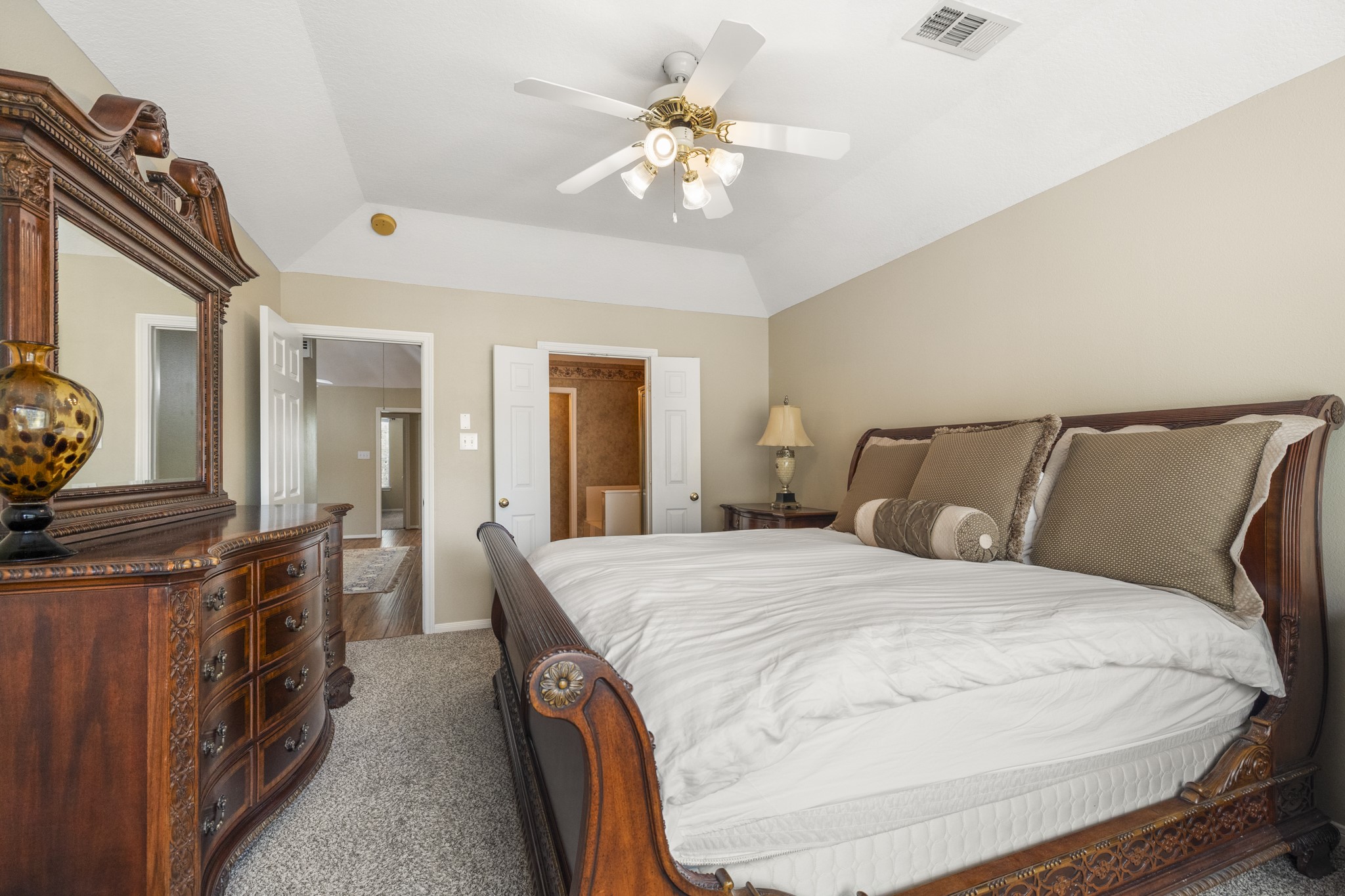6830 Jasmine Place Spring, TX 77379 - Photo 23 of 38 a spacious bedroom with a bed a dresser and potted plants
