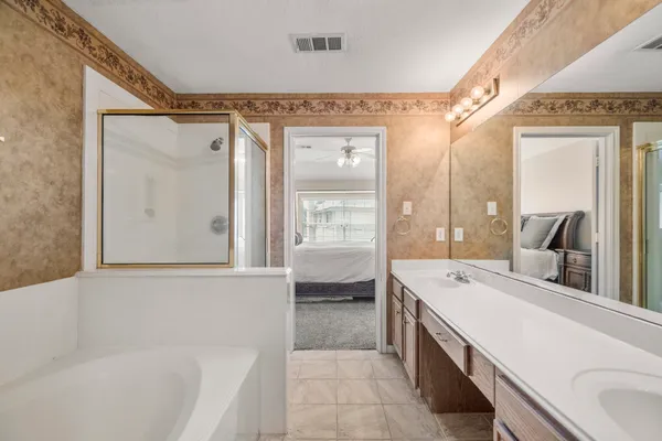 a bathroom with a tub a double vanity sink and mirror