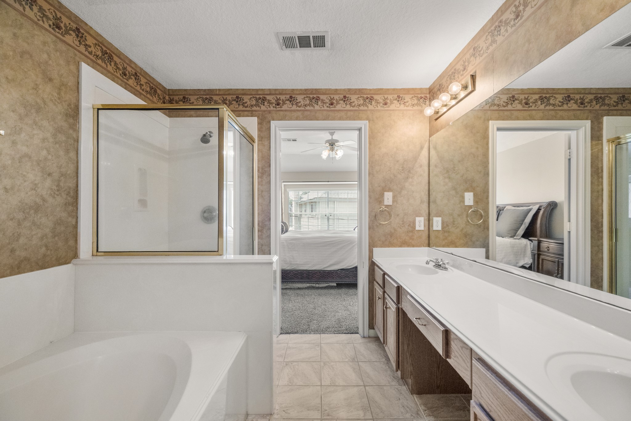 6830 Jasmine Place Spring, TX 77379 - Photo 25 of 38 a bathroom with a tub a double vanity sink and mirror