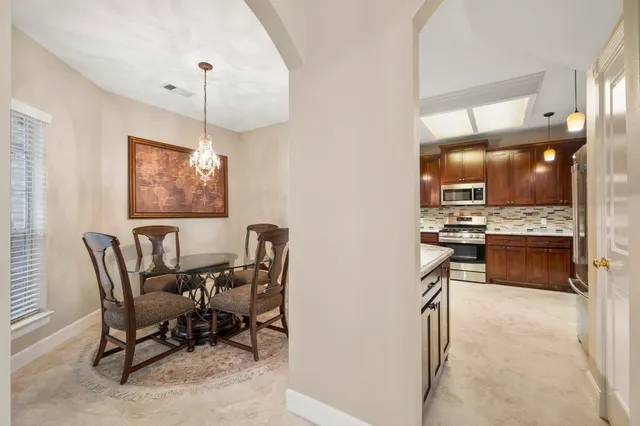 a view of a dining room with furniture and chandelier