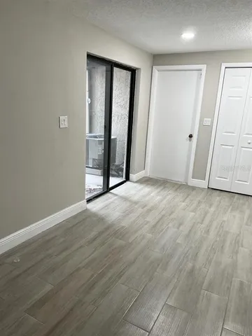 an empty room with wooden floor and mirror
