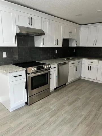 a kitchen with a stove and white cabinets