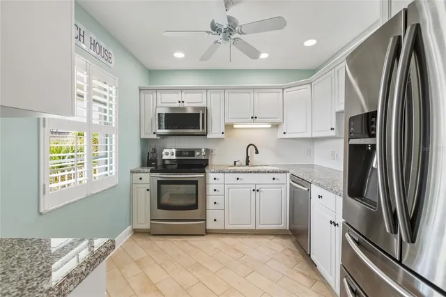 a kitchen with stainless steel appliances granite countertop a refrigerator sink and stove