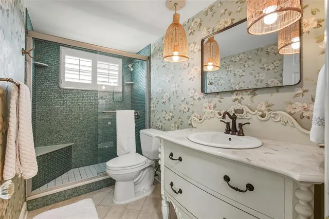 a bathroom with a sink a toilet and shower