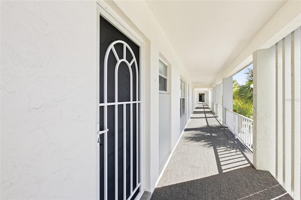 4420 Exeter Drive, Unit 303 Longboat Key, FL 34228 - Photo 25 of 42 a view of a hallway to a livingroom with wooden floor and windows