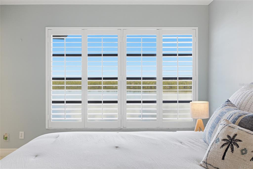 4420 Exeter Drive, Unit 303 Longboat Key, FL 34228 - Photo 10 of 42 a view of a bedroom with a bed and wooden floor