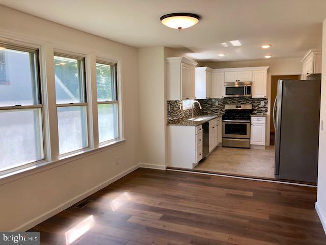 43 California Avenue, Unit A Clementon, NJ 08021 - Photo 5 of 11 a kitchen with stainless steel appliances granite countertop a stove a refrigerator and a sink with wooden floors