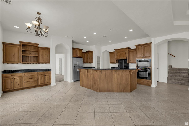 691 Rainier Drive St. George, UT 84770 - Photo 3 of 24 Kitchen featuring arched walkways, wood finish cabinetry, and a spacious island