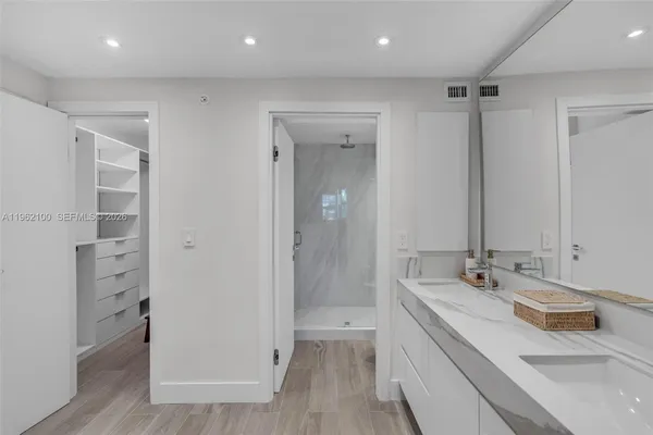 a bathroom with a double vanity sink a mirror and a shower