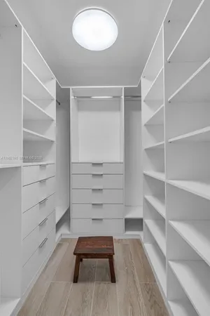 a room with walk in closet and wooden floor