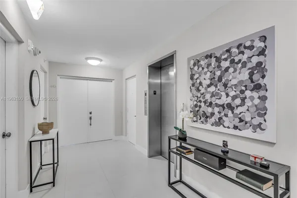 a hallway with painting on the wall and a window