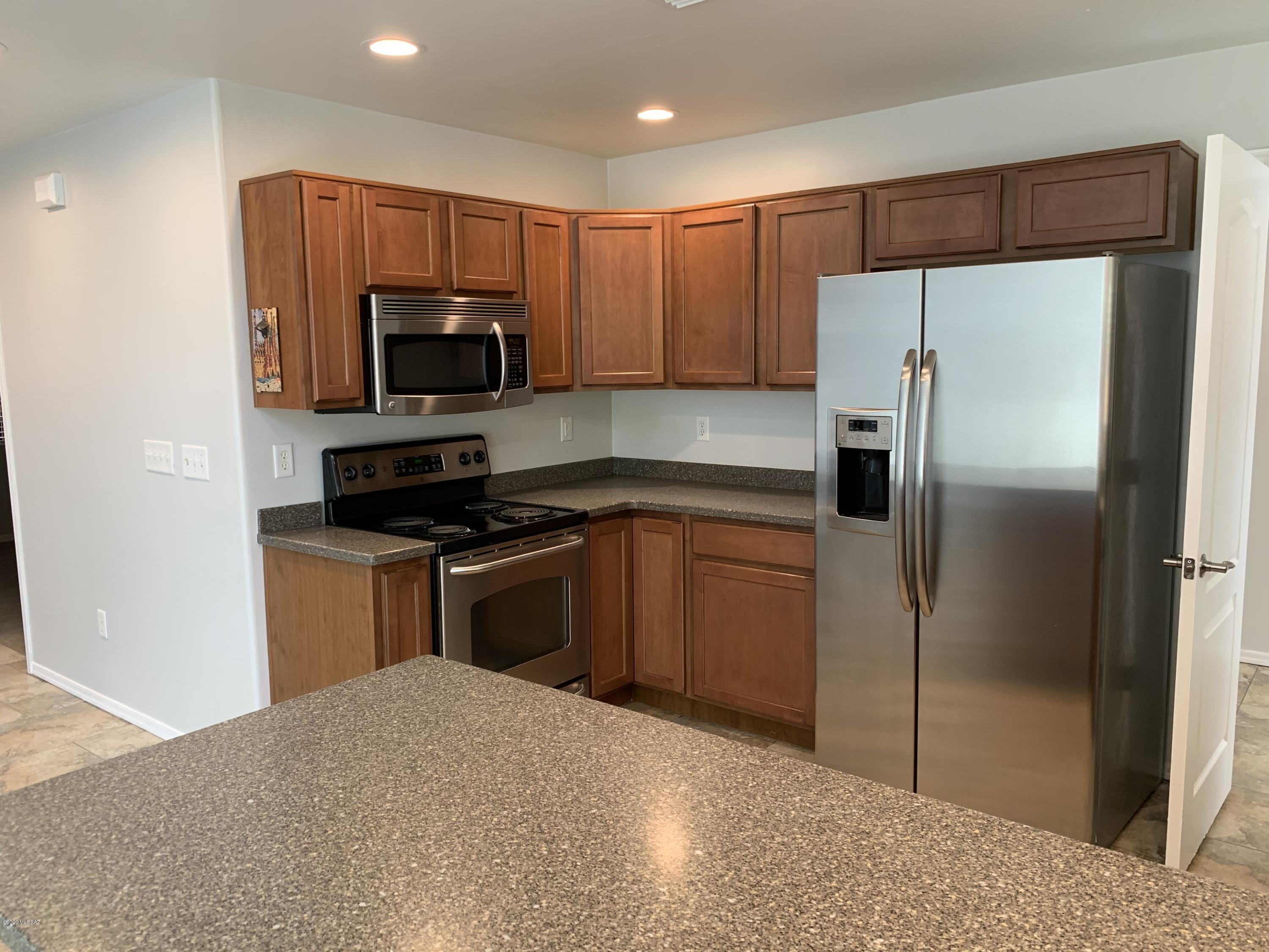 4181 North Fortune Loop Tucson, AZ 85719 - Photo 7 of 39 a kitchen with a refrigerator a microwave a sink and cabinets