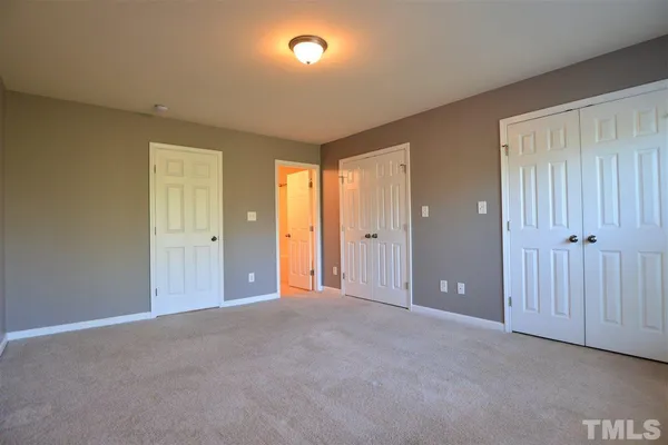 an empty room with windows and closet area