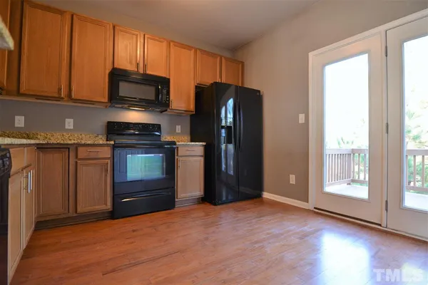 a kitchen with stainless steel appliances granite countertop a refrigerator and a stove top oven