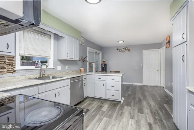 a kitchen with sink cabinets and wooden floor