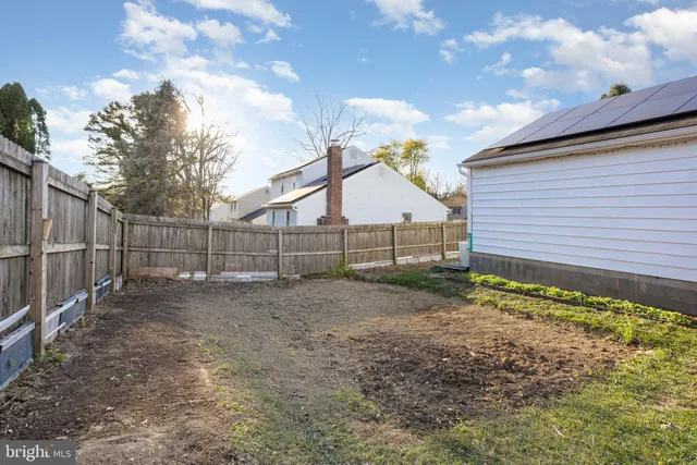 a view of a backyard with a small cabin and wooden fence