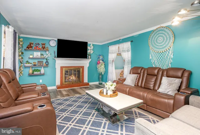 a living room with furniture a flat screen tv and a fireplace