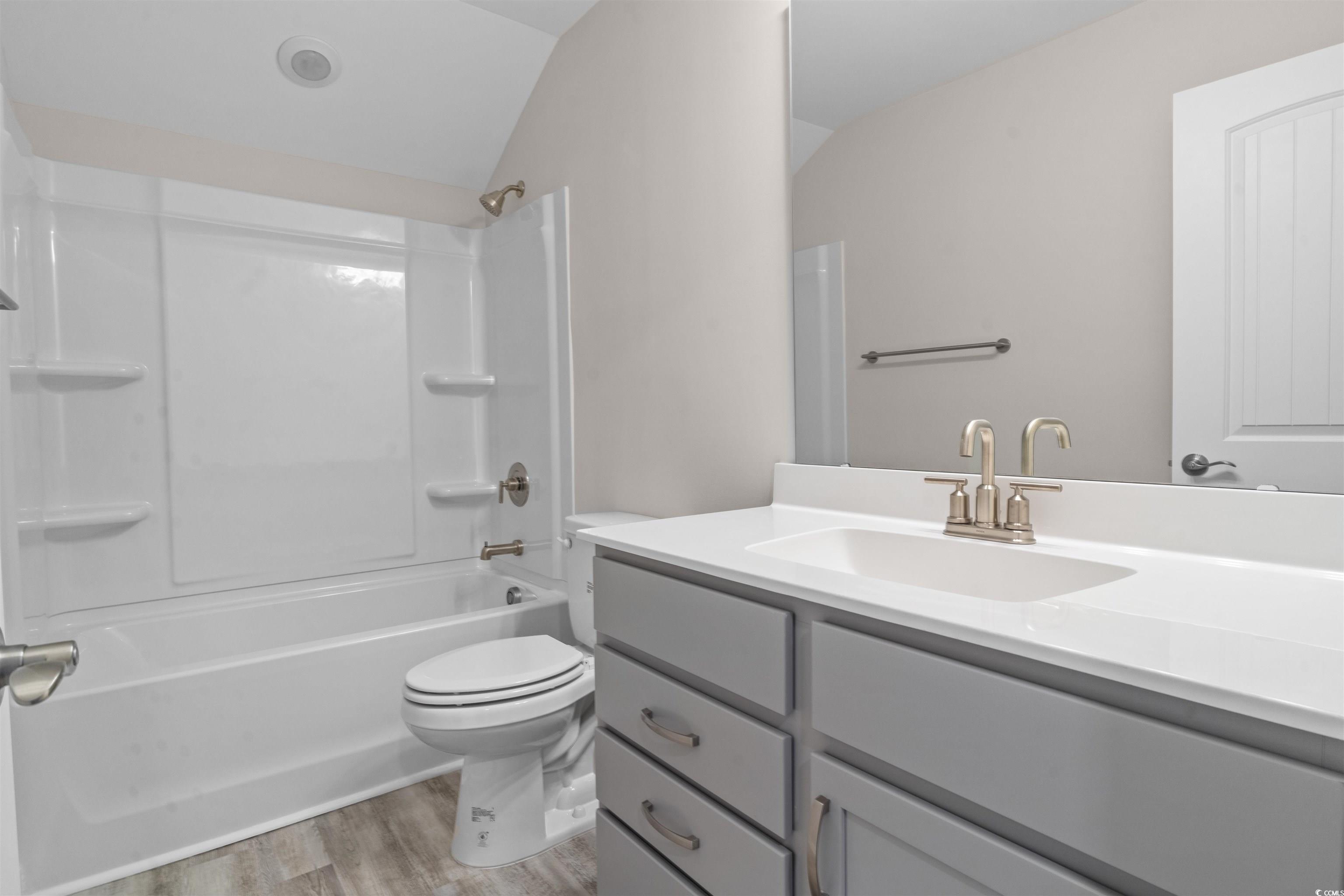 1906 Woodrush Loop Little River, SC 29566 - Photo 29 of 40 Full bathroom featuring lofted ceiling, tub / shower combination, toilet, vanity, and wood-type flooring