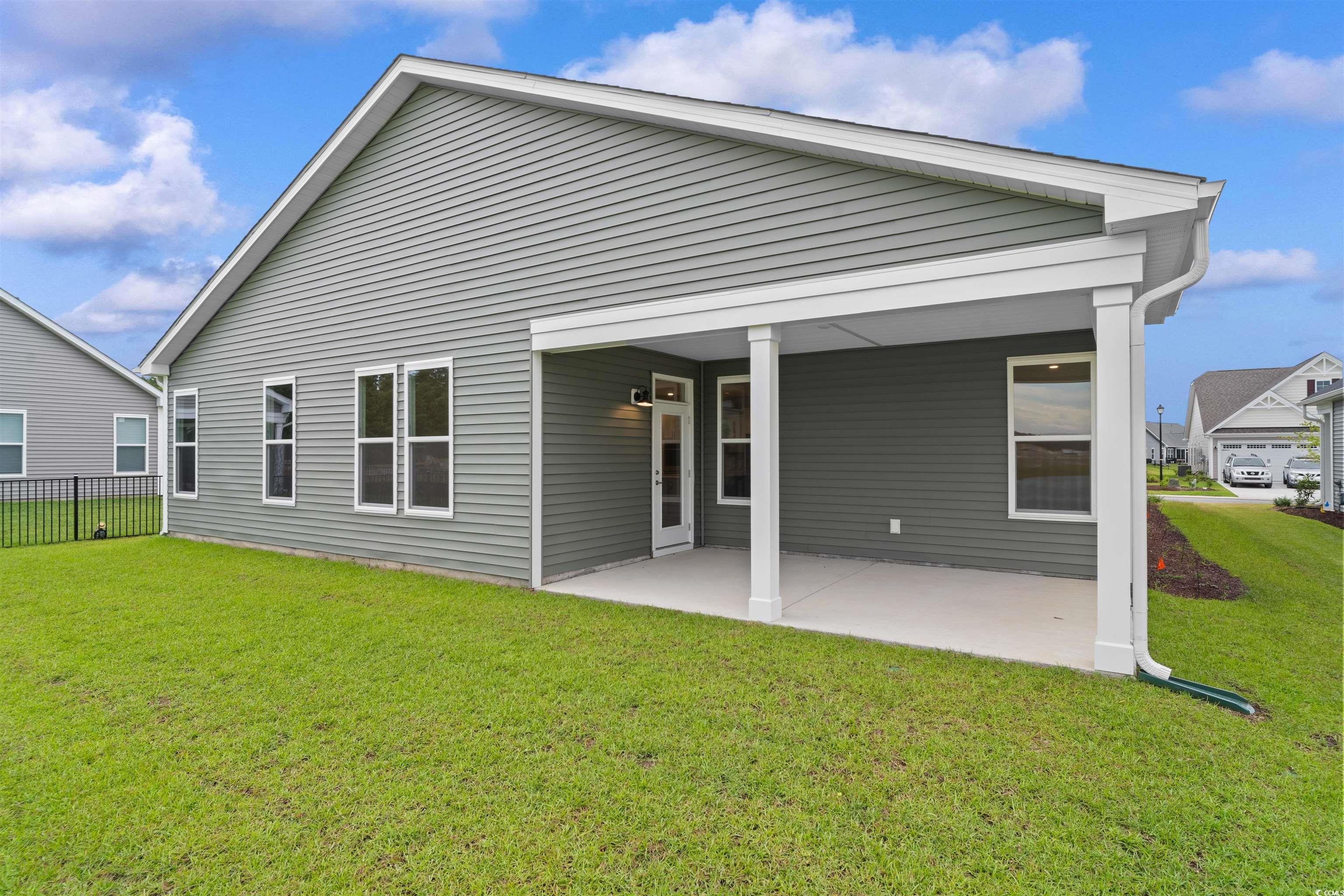 1906 Woodrush Loop Little River, SC 29566 - Photo 33 of 40 Rear view of house featuring a lawn and a patio area