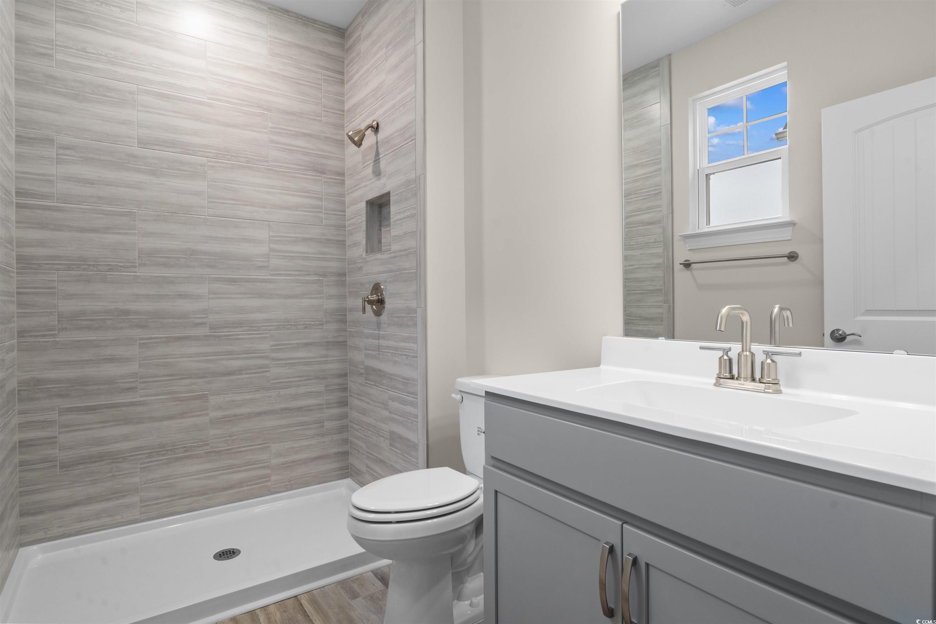 1906 Woodrush Loop Little River, SC 29566 - Photo 9 of 40 Bathroom featuring vanity, wood-type flooring, toilet, and tiled shower