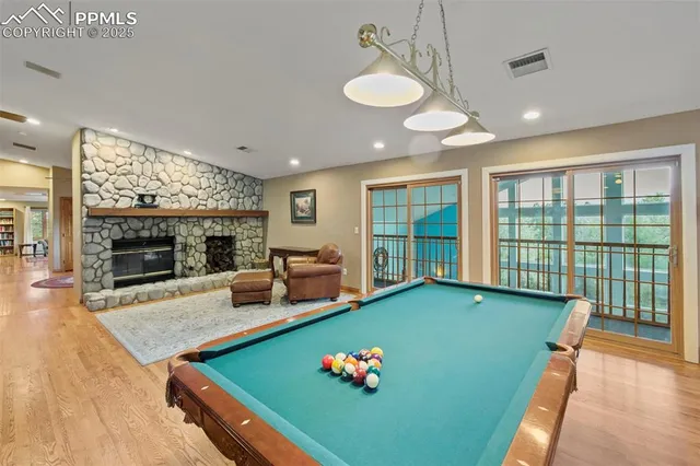 a living room with furniture pool table and a fireplace