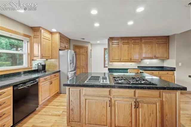 a kitchen with stainless steel appliances granite countertop a stove a sink and a granite counter tops with wooden floors