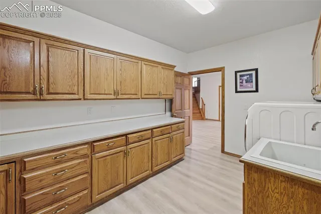 a kitchen with stainless steel appliances granite countertop a sink dishwasher stove and refrigerator with wooden floor